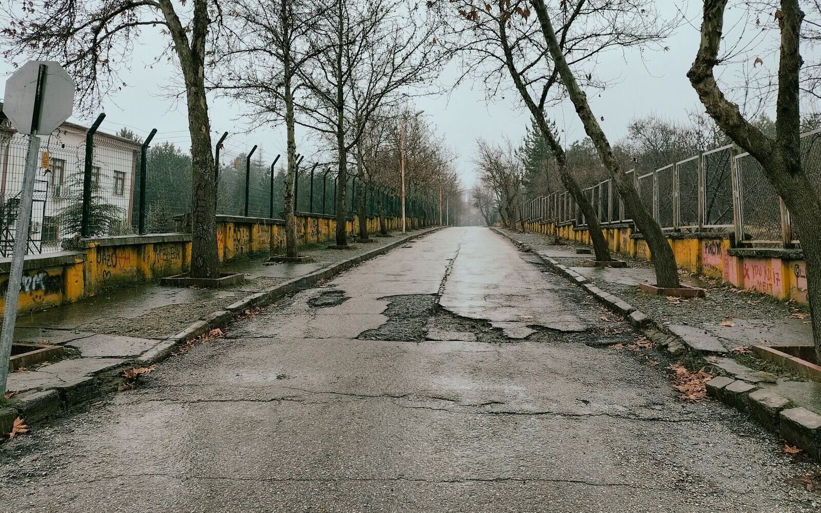Разбитая дорога с выбоинами в осенний день