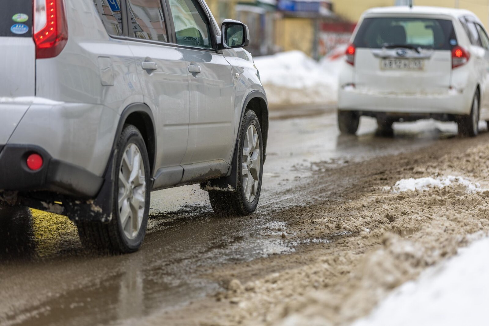 Два автомобиля на заснеженной дороге в слякоть